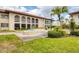 Beige condominium building with arched entryways, a fountain, and a well-maintained grassy lawn at 3690 Pinecrest St # 114, Sarasota, FL 34232