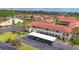Condominium complex featuring a red tile roof, covered parking, mature landscaping, and inviting architecture at 3690 Pinecrest St # 114, Sarasota, FL 34232