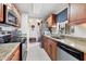 Galley kitchen features tile floor, stainless steel appliances, granite countertops, and wood cabinets at 3690 Pinecrest St # 114, Sarasota, FL 34232