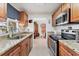 Galley kitchen features stainless steel appliances, granite countertops, tile floor, and wood cabinets at 3690 Pinecrest St # 114, Sarasota, FL 34232