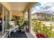 Screened in lanai featuring a white wicker chair and multiple plants overlooking the manicured lawn and garden at 3690 Pinecrest St # 114, Sarasota, FL 34232
