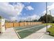 Outdoor shuffleboard court featuring numbered segments and a fenced perimeter, set under a blue sky with scattered clouds at 3690 Pinecrest St # 114, Sarasota, FL 34232