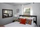 Cozy bedroom with a mirror, comfortable bed, and a window with natural light at 3717 Downer Ave, Sarasota, FL 34240