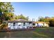 Charming single-story home featuring a wooden porch with four Adirondack chairs and colorful potted plants at 3717 Downer Ave, Sarasota, FL 34240