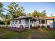 Inviting home with a cozy front porch, four chairs, fresh landscaping, and a well-manicured lawn at 3717 Downer Ave, Sarasota, FL 34240