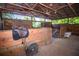 Covered horse stall with wooden construction, overhead lighting, and saddle at 3717 Downer Ave, Sarasota, FL 34240