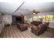 Spacious living room with leather furniture, wood floors, entertainment center, ceiling fans, and bright natural light at 3717 Downer Ave, Sarasota, FL 34240