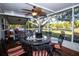 Enclosed patio with table and chairs, ceiling fan, and views of the lawn and mature trees in the back yard at 3717 Downer Ave, Sarasota, FL 34240