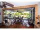Enclosed patio with metal table and chairs, ceiling fan, wood accents, and views of the beautifully landscaped yard at 3717 Downer Ave, Sarasota, FL 34240