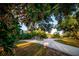 Scenic property view featuring a gravel driveway, trees, and outbuildings under a bright sky at 3717 Downer Ave, Sarasota, FL 34240