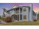 Light blue condo with screened porch, balcony, flowering bushes, and painted stairs at 3781 59Th W Ave # 3781, Bradenton, FL 34210