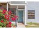 Close up of a condo with screened entry, blue door, flowering bushes, and sidewalks at 3781 59Th W Ave # 3781, Bradenton, FL 34210
