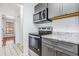 Updated kitchen appliances including a microwave, oven, and granite countertops with gray cabinets at 3781 59Th W Ave # 3781, Bradenton, FL 34210