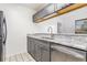 Modern kitchen with stainless steel sink and granite countertops and updated gray cabinets at 3781 59Th W Ave # 3781, Bradenton, FL 34210