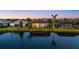 Beautiful view from across the lake of home's backyard, pool and screened enclosure at dusk at 3808 Eastham Ln, Bradenton, FL 34211