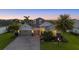 Beautiful single-story home at dusk, featuring a three-car garage, lush landscaping, and serene twilight sky at 3808 Eastham Ln, Bradenton, FL 34211