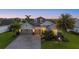Beautiful single-story home at dusk, featuring a three-car garage, lush landscaping, and serene twilight sky at 3808 Eastham Ln, Bradenton, FL 34211