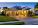 Elegant single-Gathering home with a three-car garage, lush landscaping, and a paver driveway at dusk at 3808 Eastham Ln, Bradenton, FL 34211