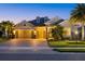 Elegant single-Gathering home with a three-car garage, lush landscaping, and a paver driveway at dusk at 3808 Eastham Ln, Bradenton, FL 34211