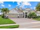 Charming single-story home featuring a three-car garage, well-manicured lawn, and lush landscaping with mature palm trees at 3808 Eastham Ln, Bradenton, FL 34211