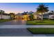 Inviting single-story home at twilight, featuring a three-car garage and lush landscaping illuminated by warm exterior lighting at 3808 Eastham Ln, Bradenton, FL 34211