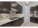Kitchen featuring gas cooktop, dark cabinets, granite counters, tile backsplash and stainless vent hood at 3808 Eastham Ln, Bradenton, FL 34211