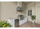 Well-equipped outdoor kitchen area with a built-in grill, granite counters, and a stainless steel fridge at 3808 Eastham Ln, Bradenton, FL 34211