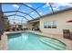 Backyard pool and patio area with a covered outdoor kitchen and screened enclosure, ideal for outdoor relaxation at 3808 Eastham Ln, Bradenton, FL 34211
