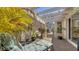 Private courtyard with lush tropical plants, a comfortable lounge chair, and access to the main house and greenhouse at 3984 Lyndhurst Ct, Sarasota, FL 34235