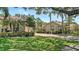 Beautiful single-story home featuring a red brick driveway, well-manicured lawn, and mature tropical landscaping at 3984 Lyndhurst Ct, Sarasota, FL 34235