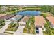 A beautiful aerial view shows three single-story homes with mature landscaping and a tranquil lake backdrop at 4016 Azurite Way, Bradenton, FL 34211