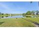 Picturesque view of a lush green backyard leading to a serene lake, perfect for nature lovers at 4016 Azurite Way, Bradenton, FL 34211