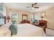 Bedroom featuring a wooden bed frame, an area rug, a ceiling fan, natural light streaming in through the windows, and a fireplace at 4016 Azurite Way, Bradenton, FL 34211