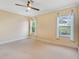 Cozy bedroom filled with natural light featuring neutral walls, plush carpet, and a ceiling fan at 4016 Azurite Way, Bradenton, FL 34211