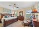 Bedroom featuring a wooden bed frame, an area rug, a ceiling fan, a dresser with mirror and natural light streaming in through the windows at 4016 Azurite Way, Bradenton, FL 34211