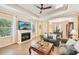 Cozy living room with a fireplace, tile flooring, and a seamless transition to the dining area at 4016 Azurite Way, Bradenton, FL 34211