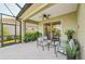 Relaxing screened patio with comfortable seating, ceiling fan, and lush plants offering a serene outdoor living space at 4016 Azurite Way, Bradenton, FL 34211
