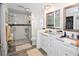 Well-lit bathroom features dual sinks, gray countertops, and a glass-enclosed shower with tile surround at 4111 E 13Th E St, Ellenton, FL 34222