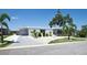 Inviting single-story home featuring a manicured lawn, mature palm trees, and a carport at 4111 E 13Th E St, Ellenton, FL 34222