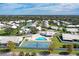 Aerial view of the community featuring mature trees, a pool, tennis court, and white roofed homes at 4313 Carol Ann Rd # 20, Sarasota, FL 34233