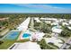 Aerial view showcases community with mature trees, pool, tennis court, and white roofed homes at 4313 Carol Ann Rd # 20, Sarasota, FL 34233
