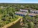 Aerial view showcasing the community with townhomes surrounded by mature trees and a pond at 4548 Chinkapin Dr, Sarasota, FL 34232