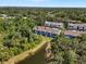 Aerial view showcasing the community with townhomes surrounded by mature trees and a pond at 4548 Chinkapin Dr, Sarasota, FL 34232