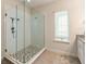 Bathroom with glass enclosed shower with tile floors and a window at 4548 Chinkapin Dr, Sarasota, FL 34232