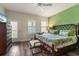 Bright bedroom features wood floors, a large bed, a walkout to the porch and lots of natural light at 4548 Chinkapin Dr, Sarasota, FL 34232