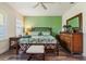 Primary bedroom with wood floors, a large bed and green accent wall at 4548 Chinkapin Dr, Sarasota, FL 34232