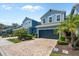 Charming two-story townhome with a dark blue exterior, brick driveway, and tropical landscaping at 4548 Chinkapin Dr, Sarasota, FL 34232