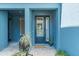 Inviting front entrance showcasing a stylish blue door, sidelights, and decorative potted plants at 4548 Chinkapin Dr, Sarasota, FL 34232