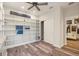 Spacious office with custom built-in shelving, laminate flooring, and ceiling fan at 4548 Chinkapin Dr, Sarasota, FL 34232