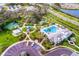 Aerial view showcases community amenities: pool, clubhouse, tennis courts, and a playground surrounded by landscaping at 4815 Deep Creek Ter, Parrish, FL 34219